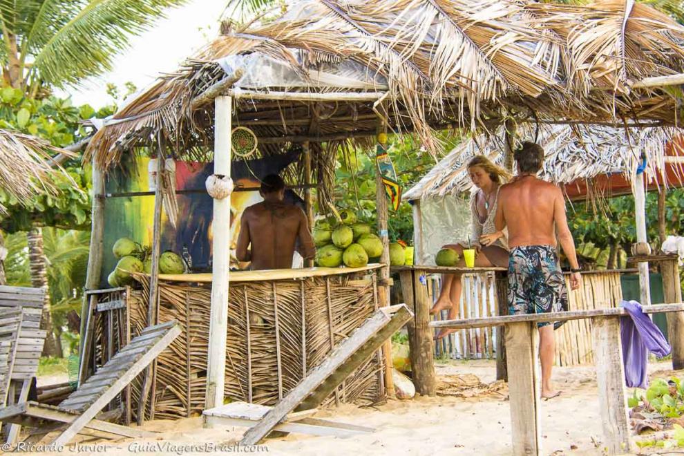 Imagem de turistas na barraca de coco na Praia da Barra Velha.